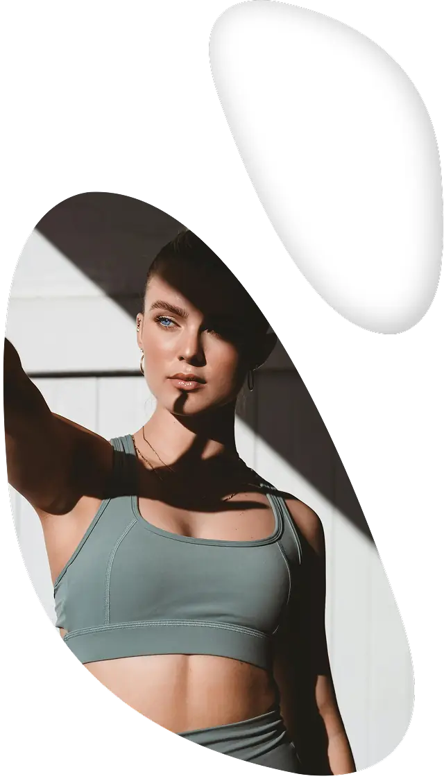 Mulher com olhar focado, vestindo roupa esportiva sob a luz forte do sol.